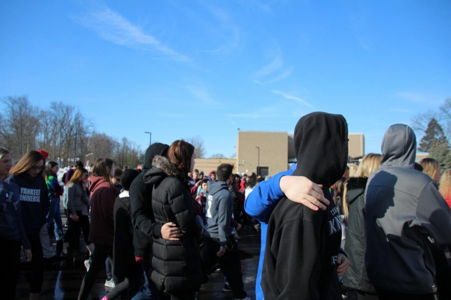 Students support each other while the name of the last Parkland victim is read. Photo by Alexa Dratch