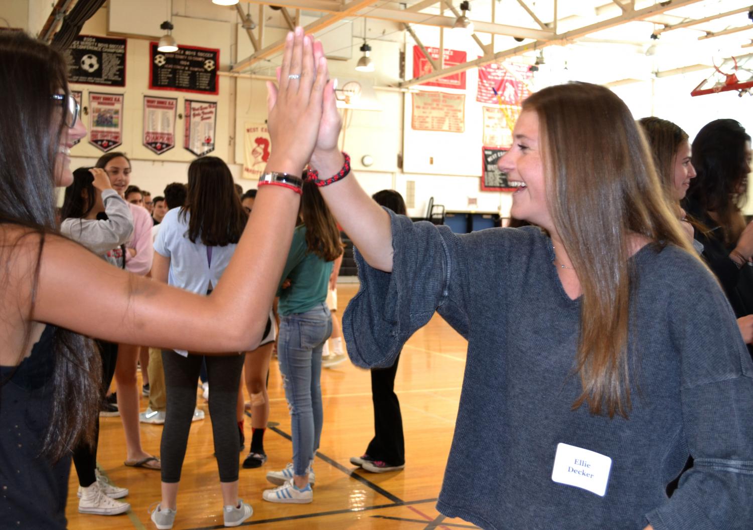 Juniors Ellie Decker and Alexis Lombardo laugh while training at a Peer Leadership Program event on June 6 at school. Nearly 70 rising seniors are getting ready to lead groups of freshmen starting in August.