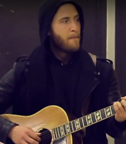 Mike Posner playing his guitar.