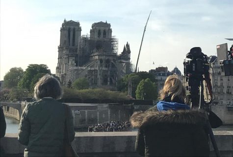 Onlookers witness the damaged exterior of Notre Dame cathedral in Paris on April 16.