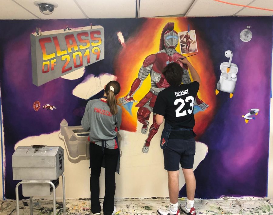 Seniors+Mark+DiGangi+and+Julia+Parzecki+continue+painting+the+class+of+2019+mural.