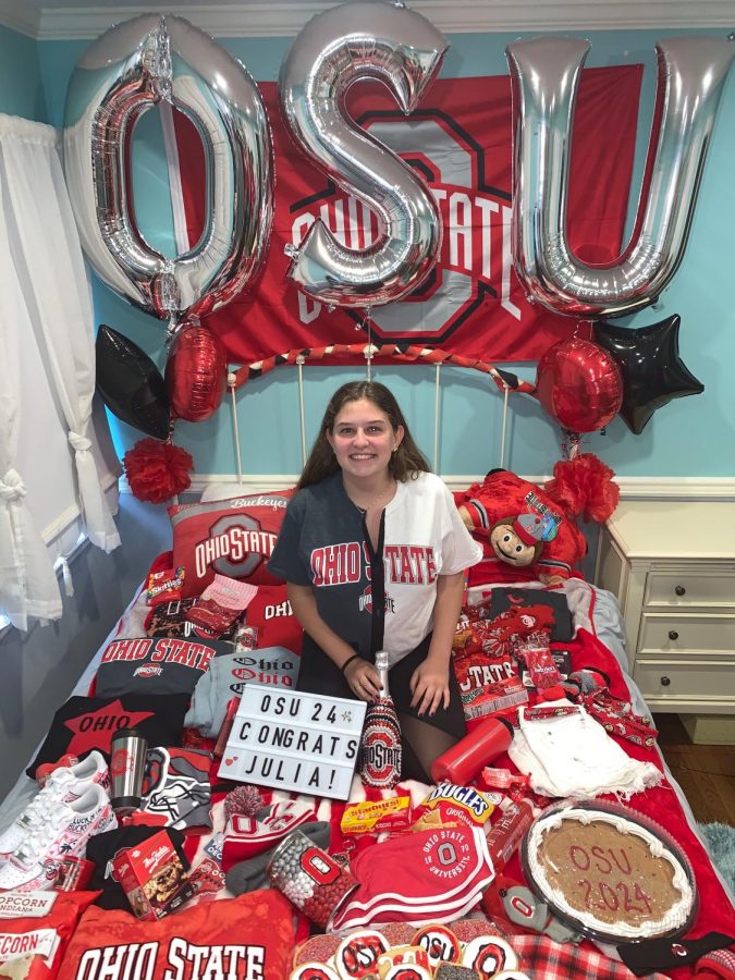 Senior Julia Rubenstein sits on her college themed bed decorated by her friends.