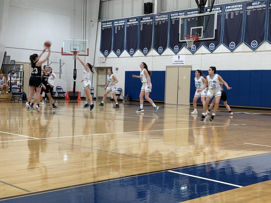Senior Katelyn Doud (23) shoots a 3-pointer Thursday, Jan. 5 against Mount St. Dominic Highschool. The school administration’s plan to bring back winter sports is to break it up into 3 sub-seasons to give each athlete a fair season. 
