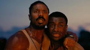 Michael B. Jordan as Smoke Moore (left) and Miles Caton as Sammie Moore (right)