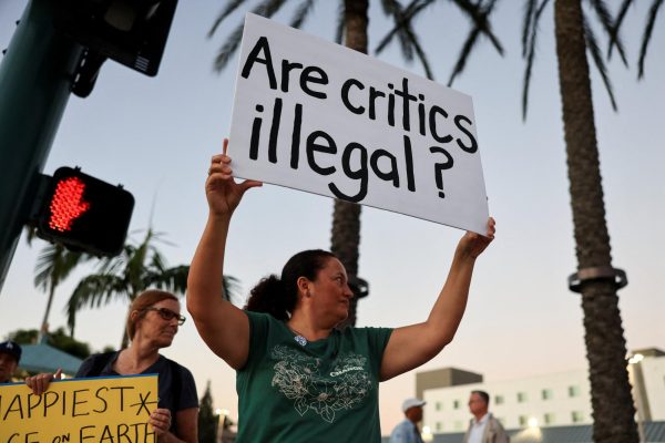 People hold signs during a protest outside Disneyland, after Jimmy Kimmel's late-night talk show was suspended for remarks he made regarding Charlie Kirk's assassination, in Anaheim, California, U.S. September 19, 2025. REUTERS/David Swanson