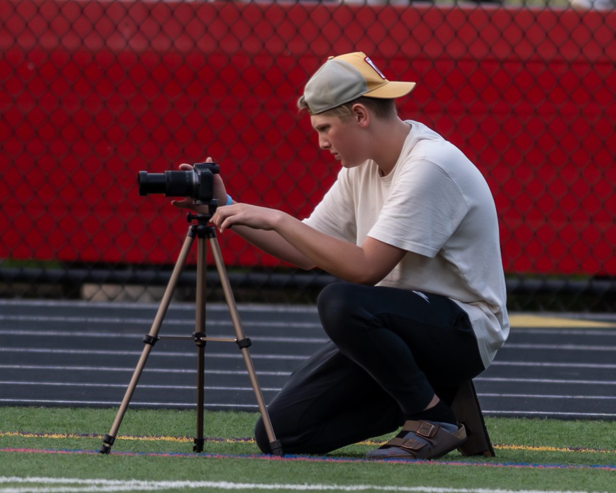 Owen Lieberman pictured with his camera on the sidelines of a game. 