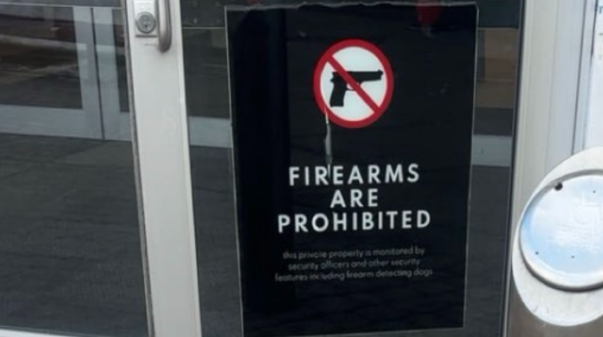 Sign on entrance door to Willowbrook Mall signals that firearms are not allowed within the mall.

